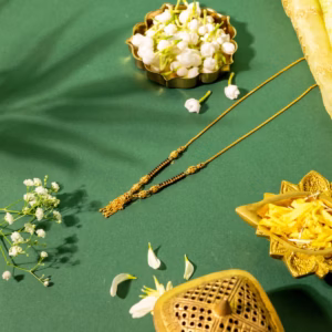 Delicate gold mangalsutra with black beads and small gold tassel